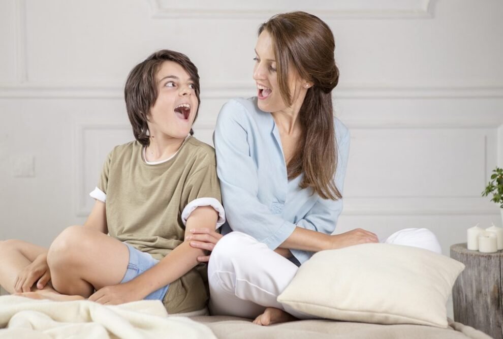Founder Rosica laughing with her son Jarin on a wool-dressed bed