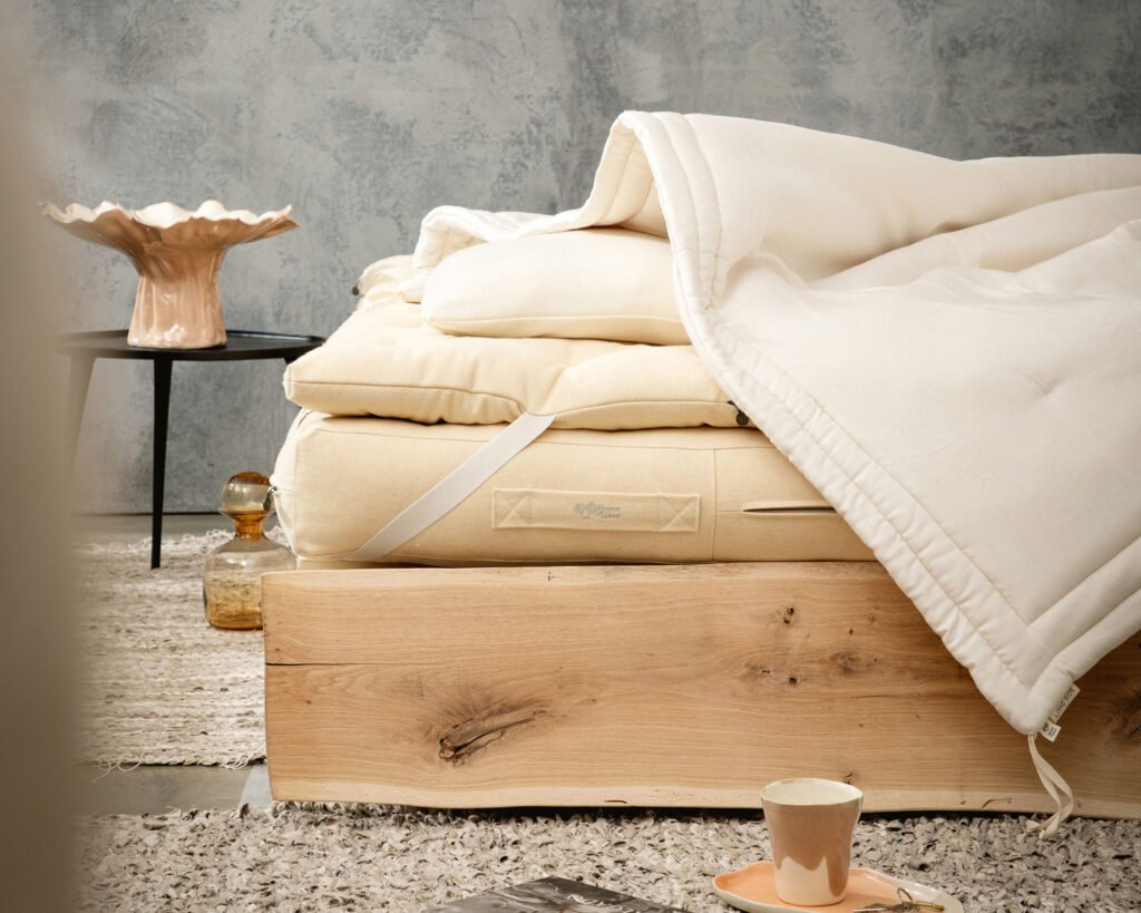 Wool mattress, topper and duvet stacked on an oak platform bed
