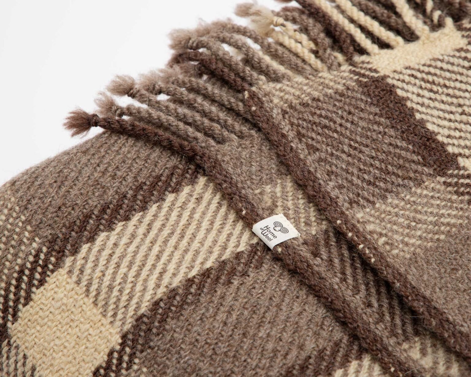 Checkered wool blanket spread over a bed