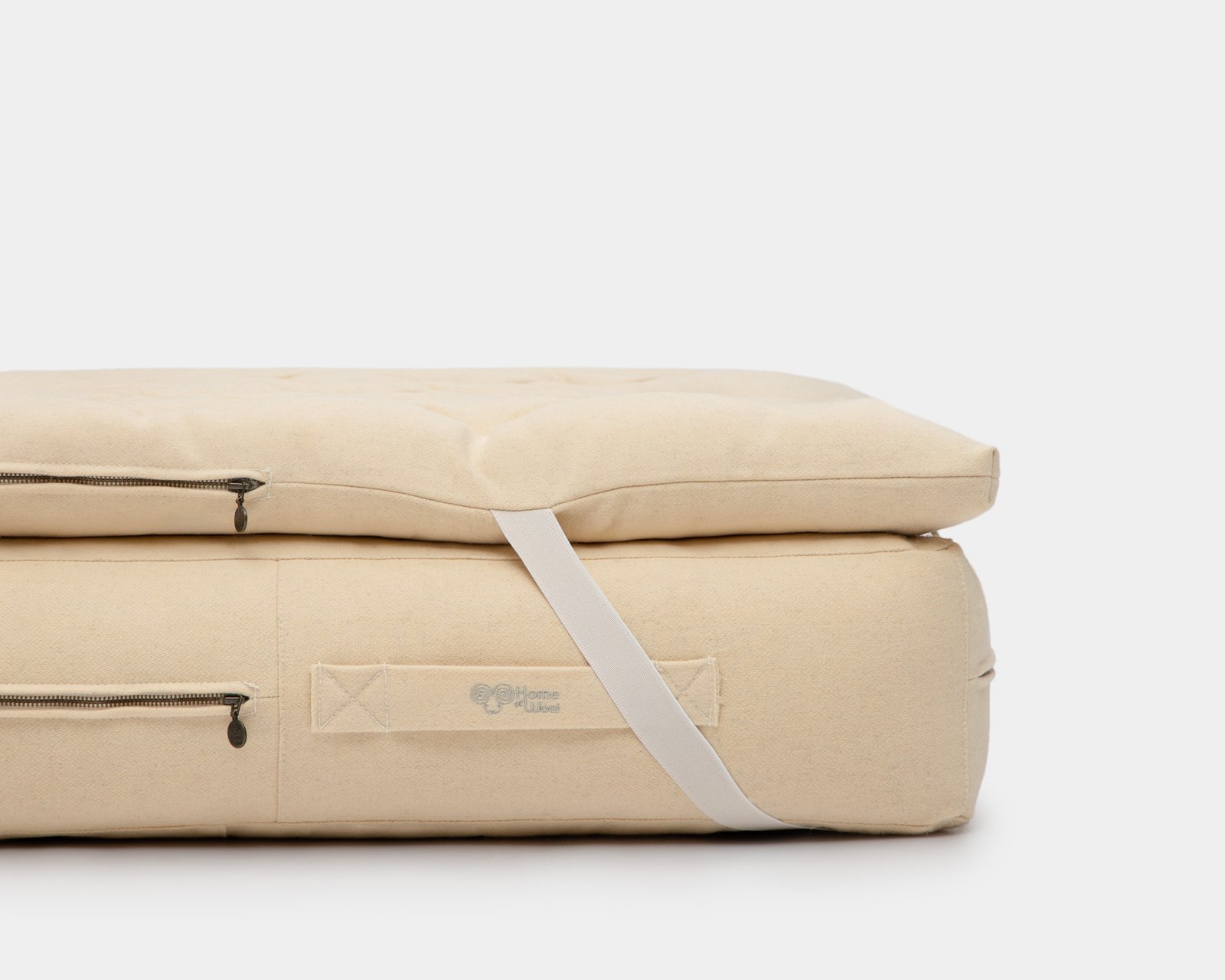 Wool mattress topper folded with carry strap