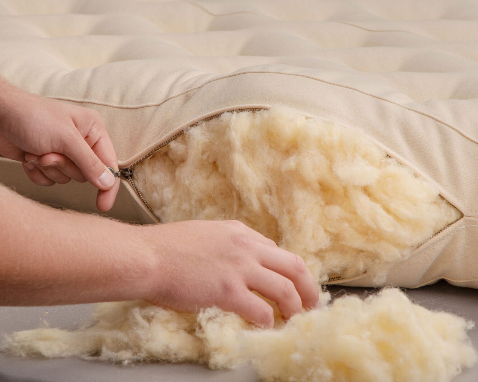 A wool mattress opened to show its natural wool filling