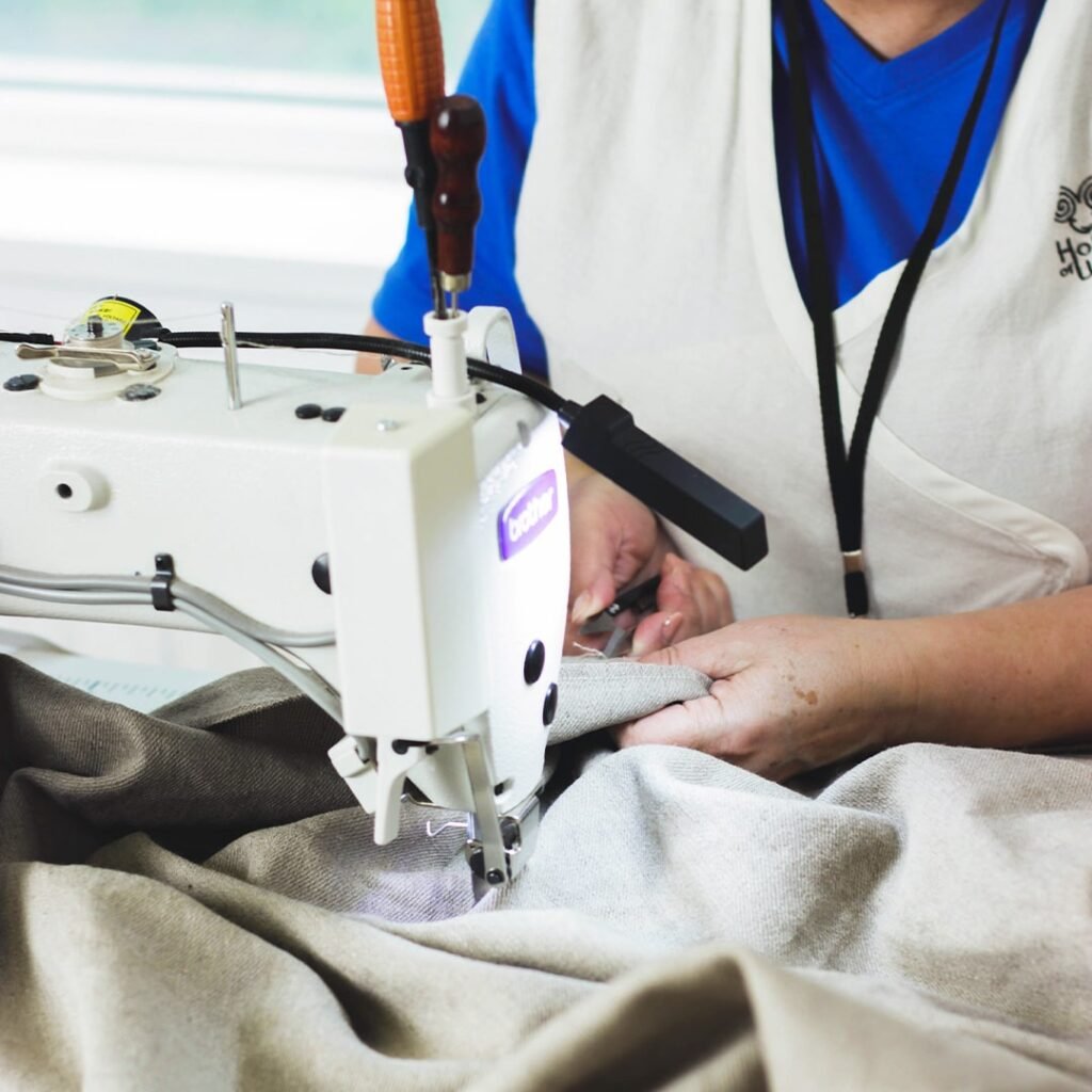 An artisan sewing a wool piece at the workshop